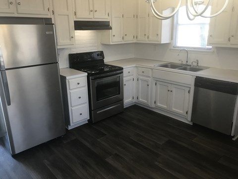 A kitchen with a stainless steel refrigerator and black stove.