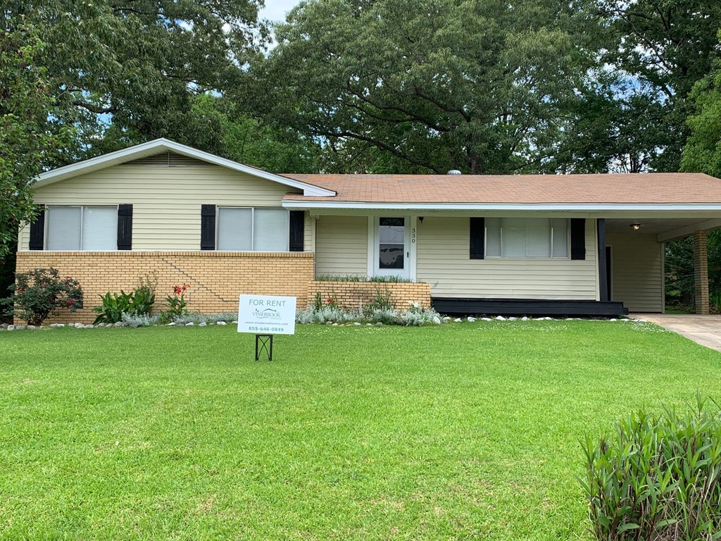 A house with a for rent sign in front of it.