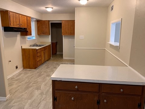 A kitchen with wooden cabinets and a white countertop.