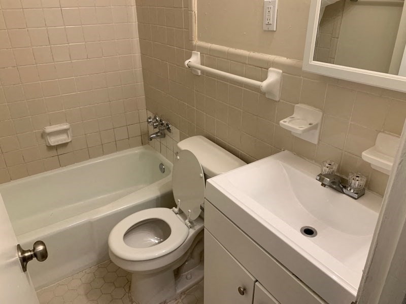 a bathroom with a toilet and a tub and a sink