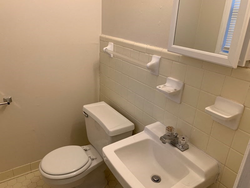 a bathroom with a sink toilet and a mirror
