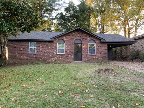 a brick house with a yard in front of it