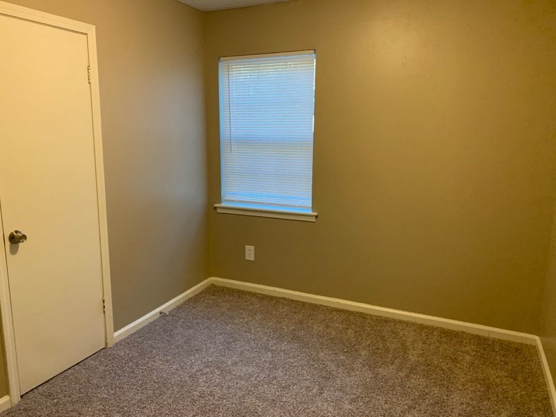 a empty room with a window and a door