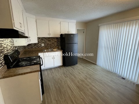 A kitchen with white cabinets and a black stove top oven.