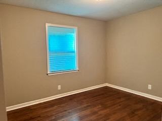 a empty room with a window and wooden floors