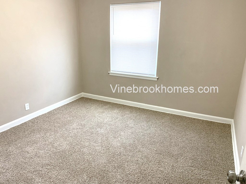 an empty room with carpet and a window
