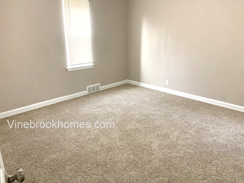 a room with a carpeted floor and a window