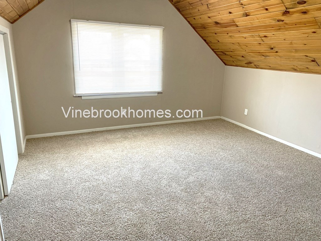 a small room with carpet and a window