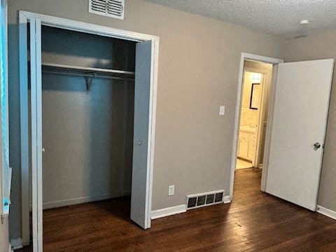 an empty living room with an open door to a closet