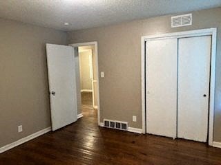 an empty living room with a wood floor and white doors
