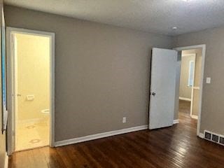 an empty living room with a door to a bathroom