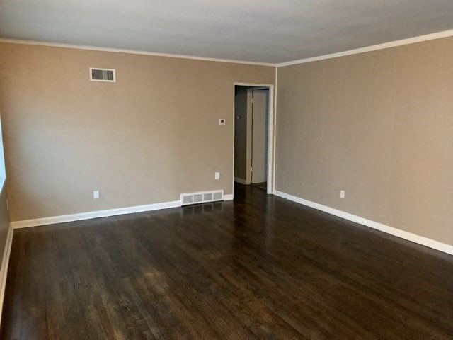 an empty living room with wooden floors and a door