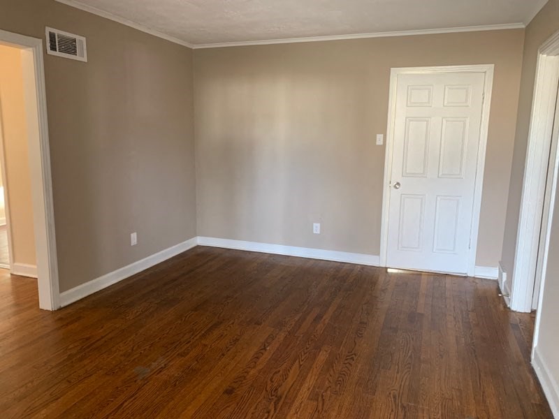 an empty room with wooden floors and a white door