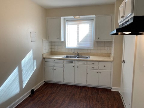 a kitchen with white cabinets and a sink and a window