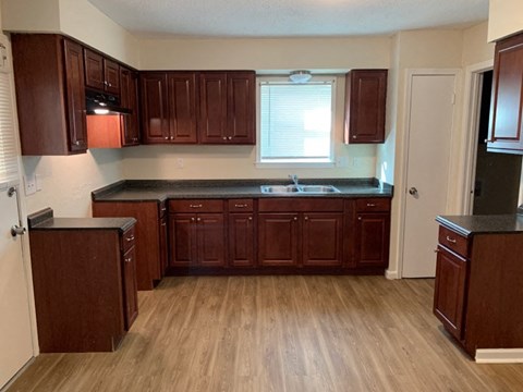 A kitchen with wooden cabinets and a black countertop.