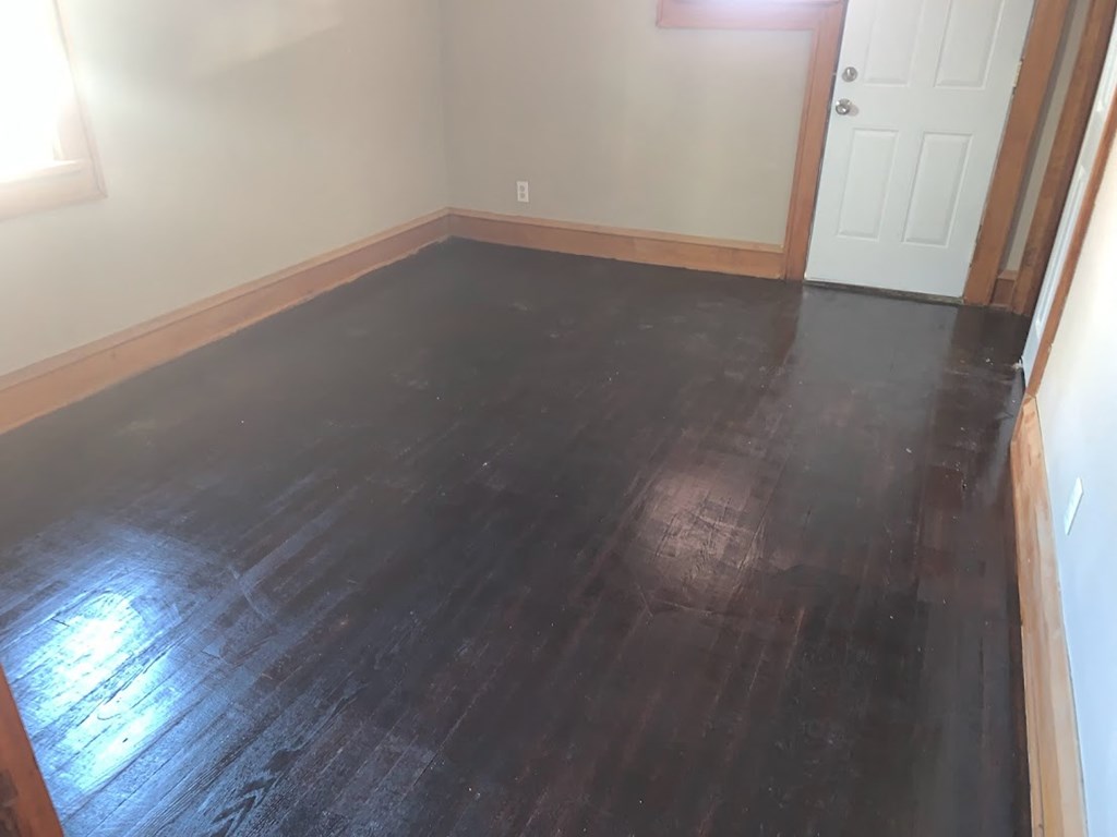 a living room with a wooden floor and a white door