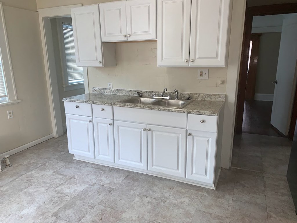 a kitchen with white cabinets and a sink
