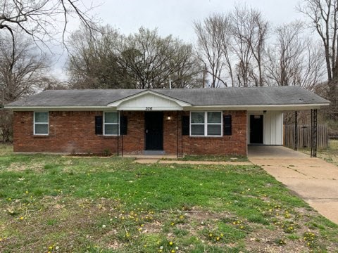 a small brick house with a yard and trees