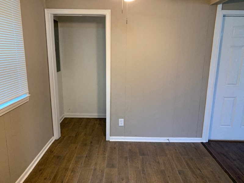 an empty room with a white door and a wood floor