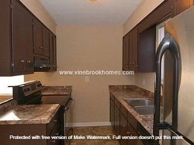 A kitchen with brown cabinets and a sink.