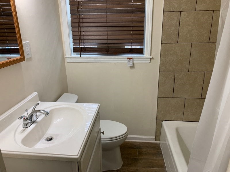 a bathroom with a toilet and a sink and a window