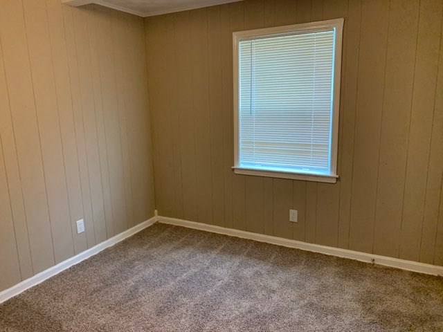 an empty room with a window and a carpet