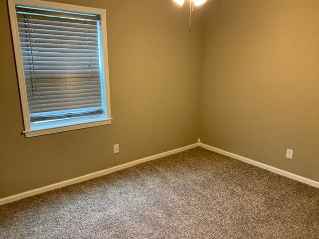 a empty room with a window and carpet