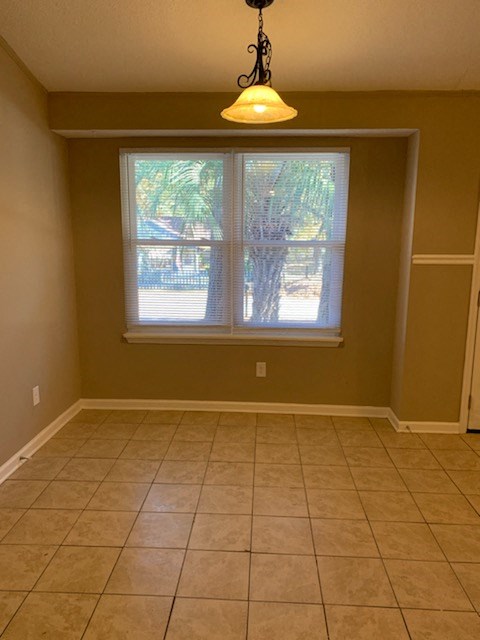 a living room with a large window and a tiled floor