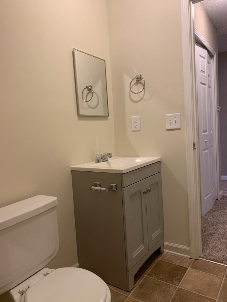 a bathroom with a toilet sink and a mirror