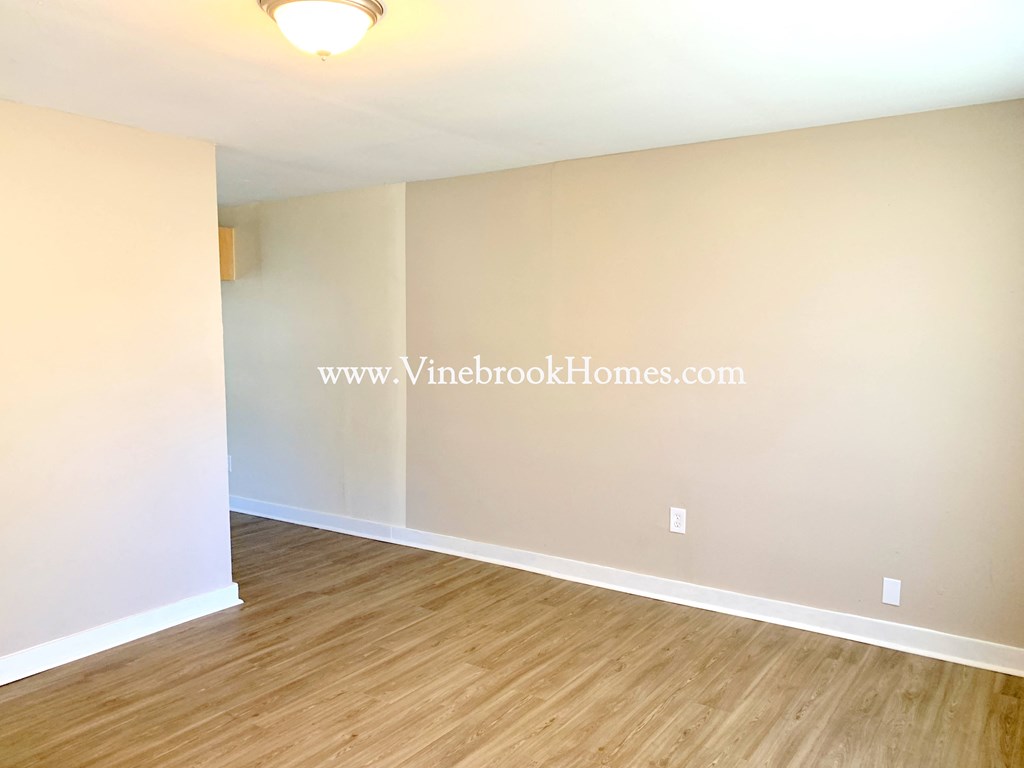 an empty living room with white walls and wood floors and a white
