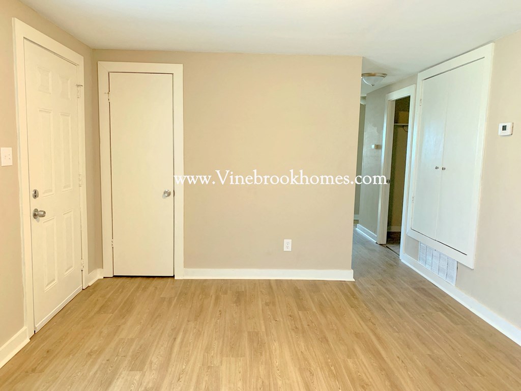a bedroom with a closet and a door to a hallway