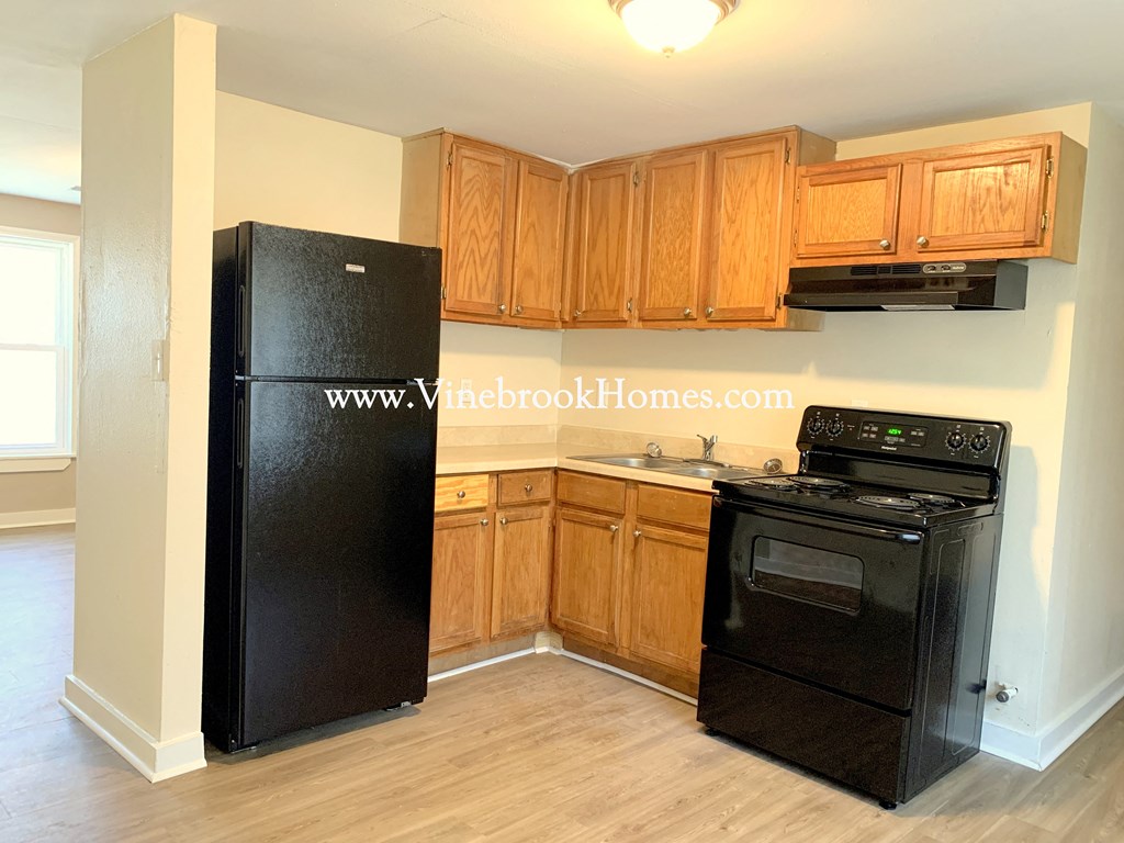 a small kitchen with black appliances and wooden cabinets