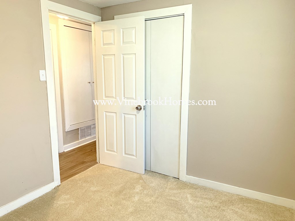 a closet in a bedroom with two doors and a door to a closet