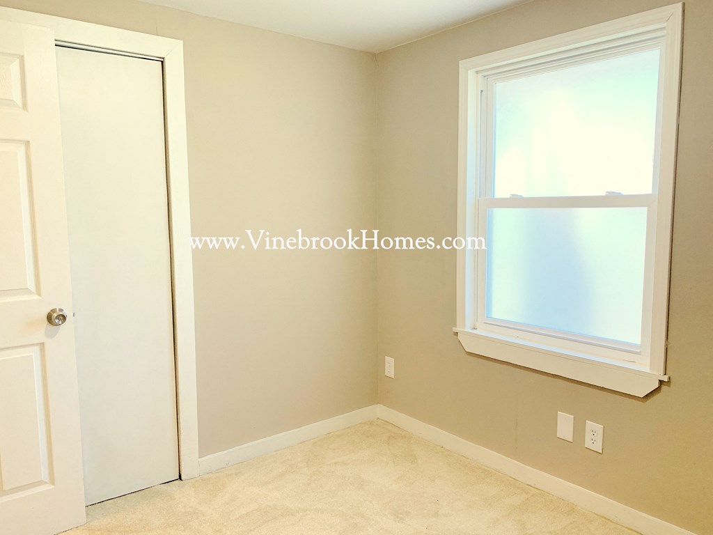 a bedroom with a window and a closet and a door