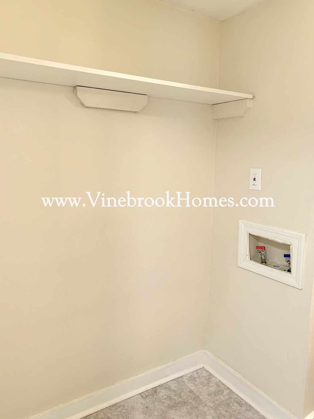 a small room with a white wall and a white shelf with a light on it