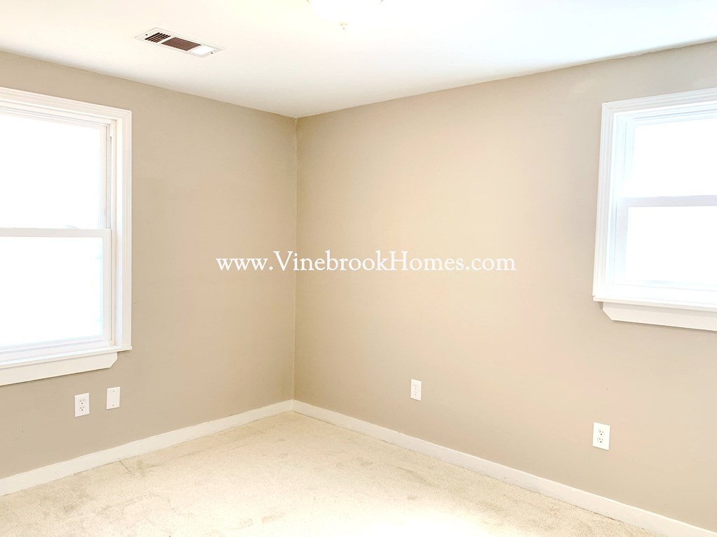 a corner of a room with two windows and a marble floor