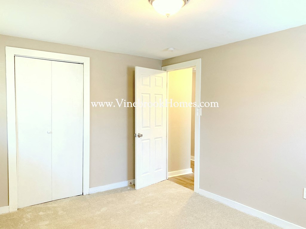 a bedroom with two closet doors and a door to a closet