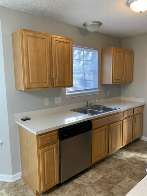 a kitchen with wooden cabinets and a sink and a window