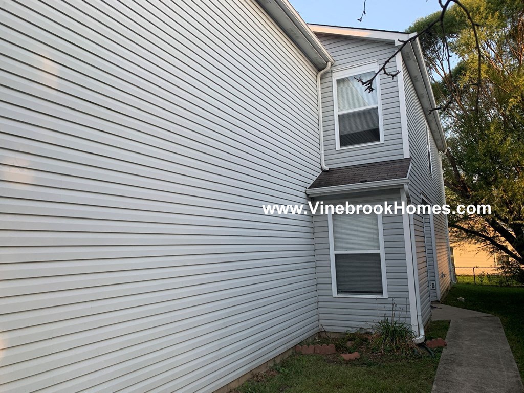 a view of the side of a white house with a window