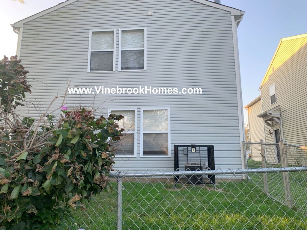 the back of a house behind a chain link fence