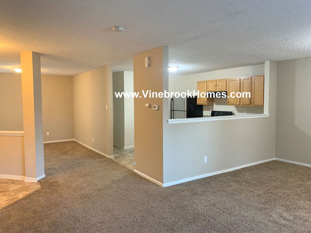 a large living room with a kitchen and a large window
