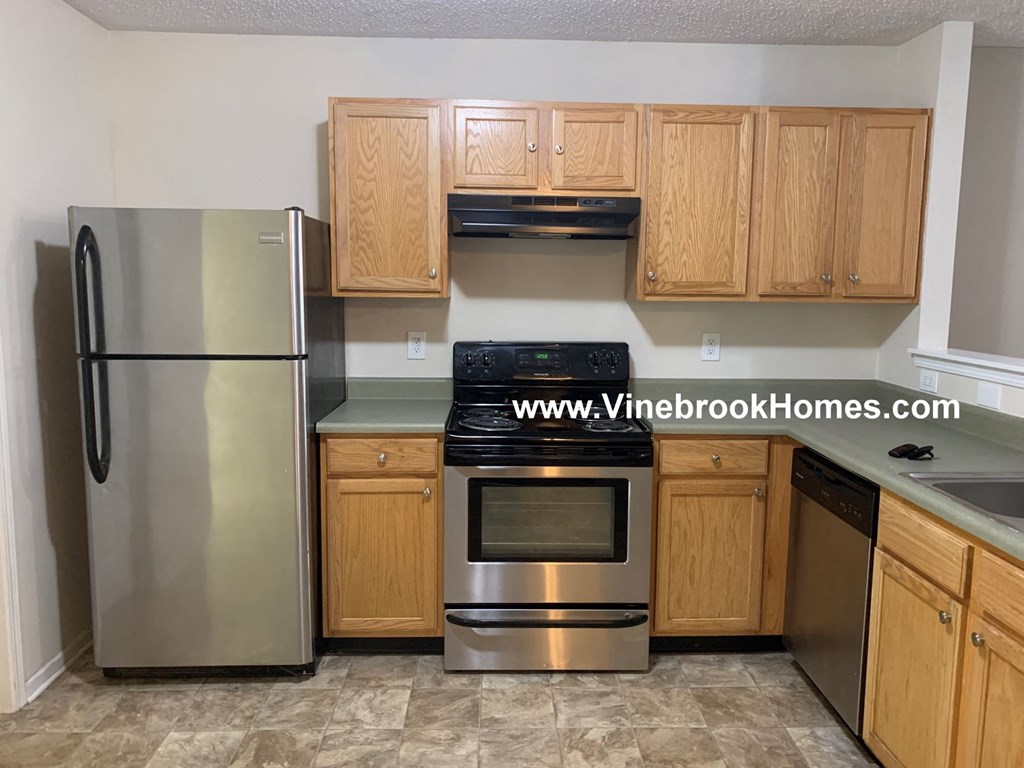 a kitchen with wooden cabinets and stainless steel appliances