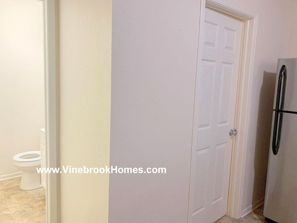 a bathroom with a white door and a toilet and a closet