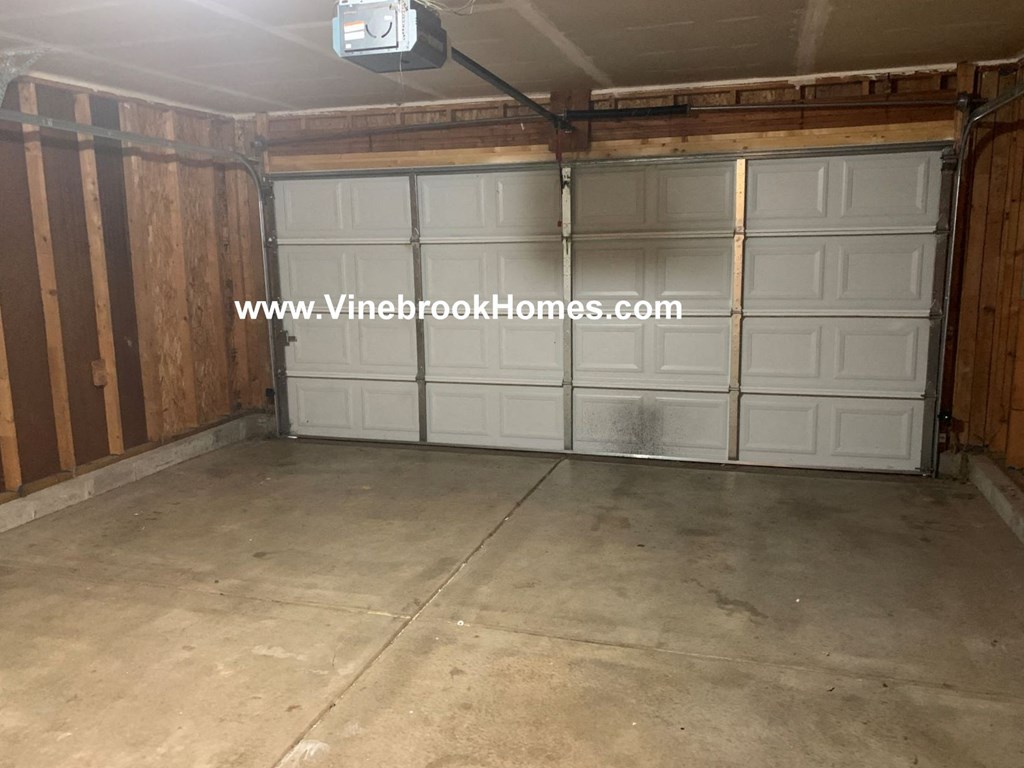 a garage with white doors and a concrete floor