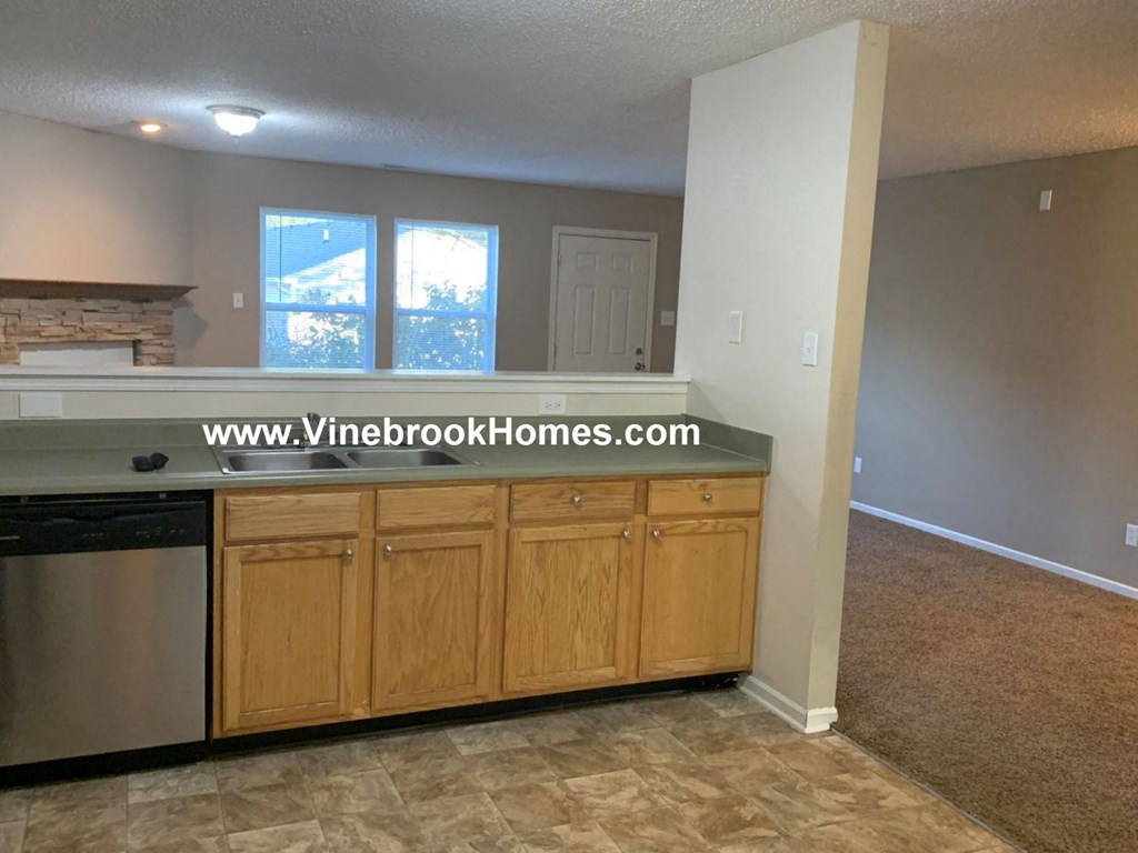 a kitchen with wooden cabinets and a dishwasher and a window