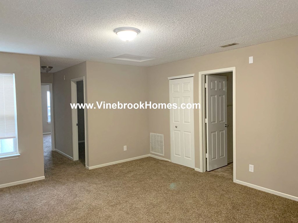 a bedroom with a closet and a door to a bathroom