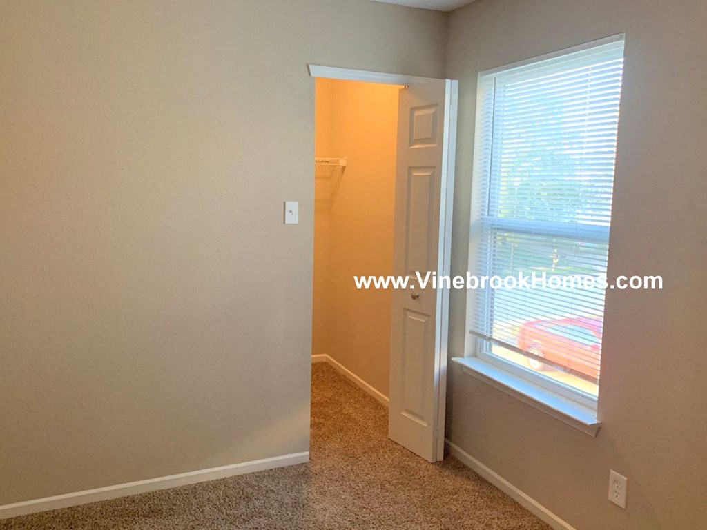 a bedroom with a window and a door to a closet