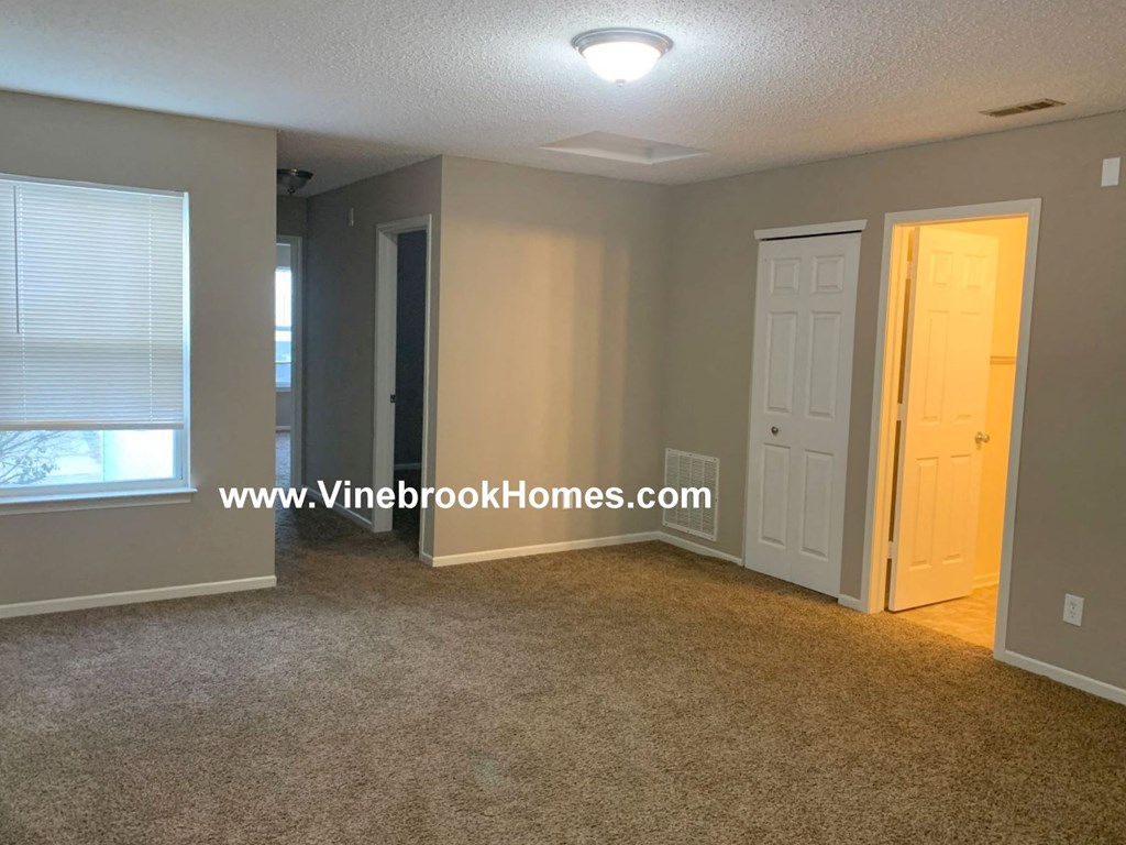a small living room with a door to a closet and a window