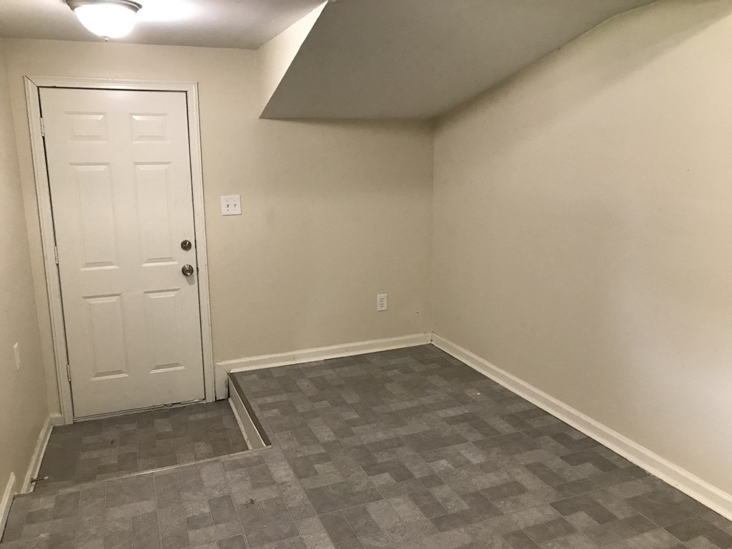 a empty room with a white door and a tiled floor