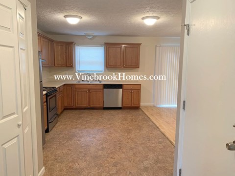 A kitchen with wooden cabinets and a tiled floor.